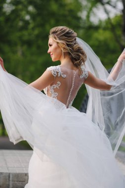 Güzel sarışın gelin bahar bahçesinde poz veriyor.