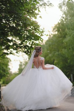 Güzel sarışın gelin bahar bahçesinde poz veriyor.