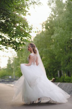 Güzel sarışın gelin bahar bahçesinde poz veriyor.