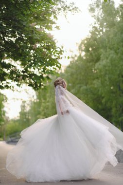 Güzel sarışın gelin bahar bahçesinde poz veriyor.