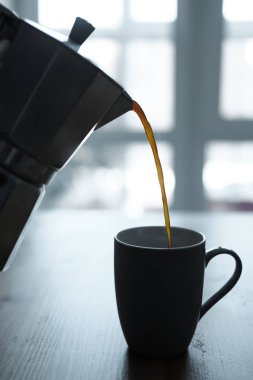 Pouring coffe from pot to cup