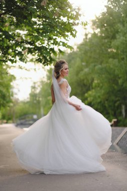 Güzel sarışın gelin bahar bahçesinde poz veriyor.