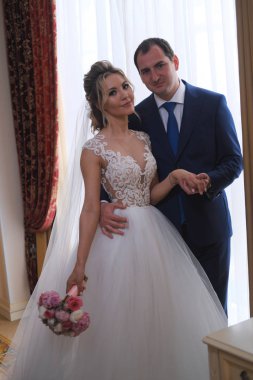 Odada poz veren yeni evlilerin portresi.