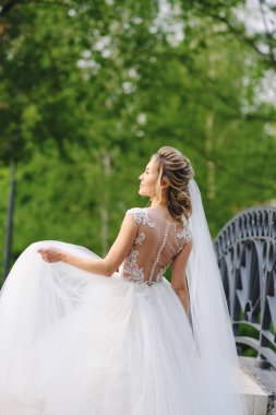 Güzel sarışın gelin bahar bahçesinde poz veriyor.