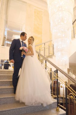 Sarışın gelin ve esmer damat birlikte poz veriyorlar.. 