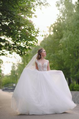 Güzel sarışın gelin bahar bahçesinde poz veriyor.