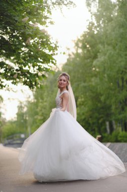 Güzel sarışın gelin bahar bahçesinde poz veriyor.