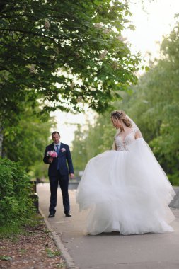 Güzel yeni evliler bahar parkında poz veriyorlar.