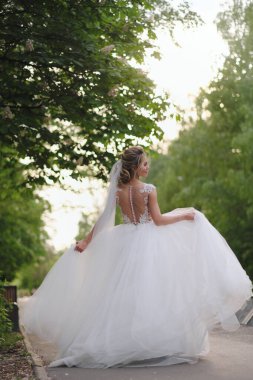 Güzel sarışın gelin bahar bahçesinde poz veriyor.