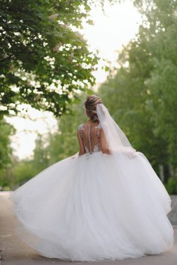 Güzel sarışın gelin bahar bahçesinde poz veriyor.