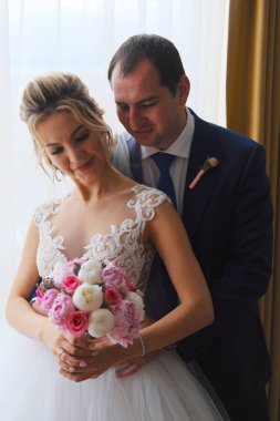 Odada poz veren yeni evlilerin yakın plan portresi.