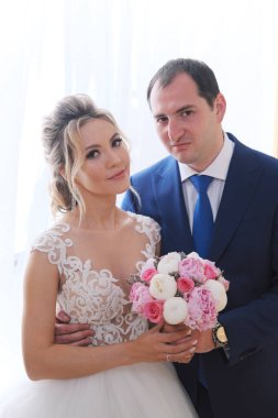 Odada poz veren yeni evlilerin portresi.