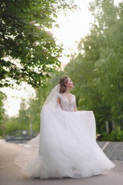 Güzel sarışın gelin bahar bahçesinde poz veriyor.