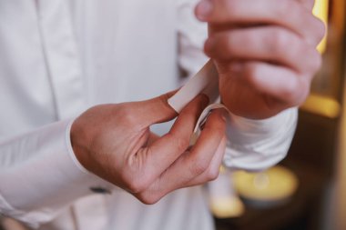 Close view of man buttoning shirt