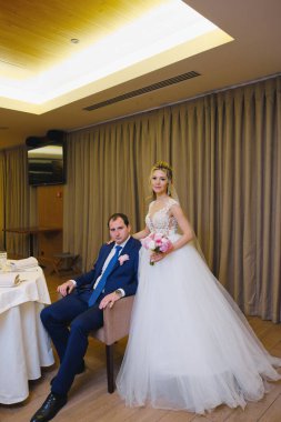 Odada poz veren yeni evlilerin portresi.