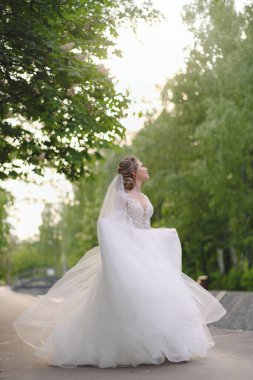 Güzel sarışın gelin bahar bahçesinde poz veriyor.