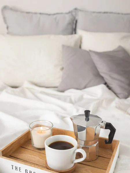 Tray with coffee and candle served on bed.