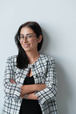 Gözlüklü esmer bir kadının stüdyo fotoğrafı.