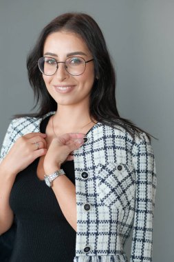 Gözlüklü esmer bir kadının stüdyo fotoğrafı.