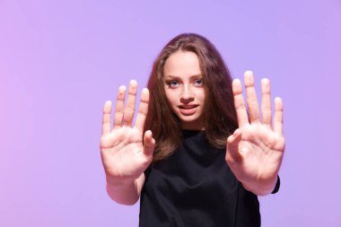 Stüdyoda genç bir kadının elleriyle durduğunu gösteren bir fotoğraf. 