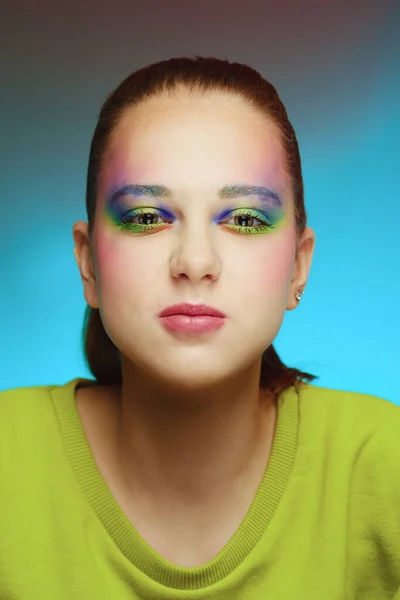 Close-up portrait of a beautiful young girl in a green knitted dress with bright color makeup — Stock Photo, Image