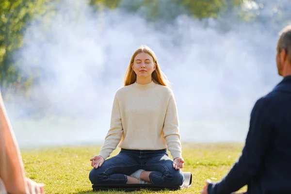 Mujer practica yoga y medita en la posición de loto en el parque — Foto de Stock