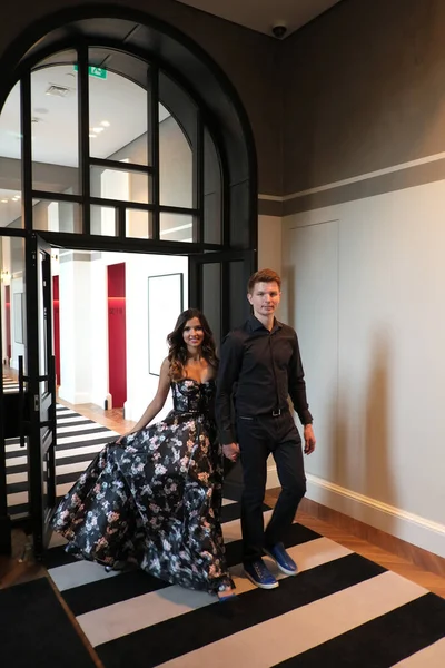 아름다운 드레스를 입은 아름다운 커플 과검은 셔츠와 바지를 입은 남자가 아름다운 실내 건물에 있습니다 — 스톡 사진