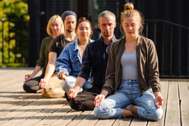 Bir grup genç parkta meditasyon yapıyor.. 