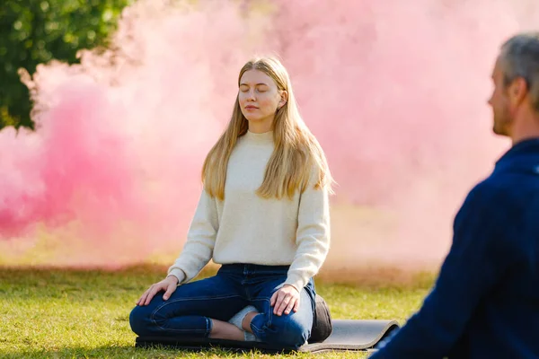 Mujer practica yoga y medita en la posición de loto en el parque — Foto de Stock