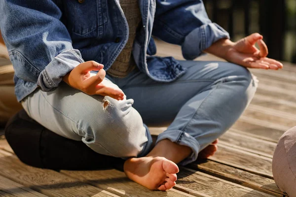 Jóvenes deportistas practicando yoga, haciendo ejercicio Padmasana, pose de Loto, con gesto mudra, ejercitándose . — Foto de Stock