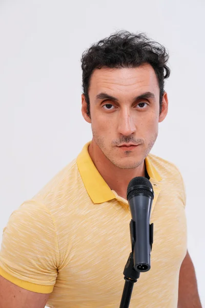 Estúdio retrato de homem animado com um microfone contra fundo liso . — Fotografia de Stock