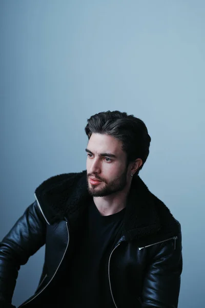 A large portrait of a stylish young man with a beard and dark hair in a black leather jacket — Stock Photo, Image