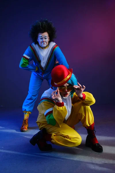 Dwóch klaunów mężczyzna i kobieta z makijażem w jasnokolorowych dresach w stylu lat 80-tych. — Zdjęcie stockowe