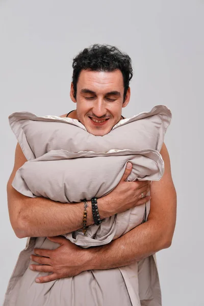 Studio πορτρέτο του νυσταγμένου άνδρα κρατώντας μαξιλάρια — Φωτογραφία Αρχείου