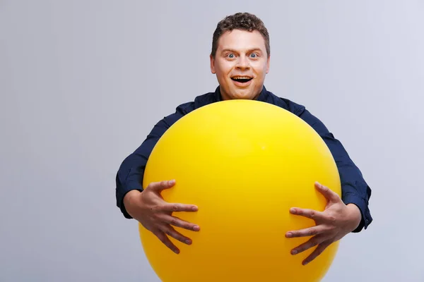 Portrait studio de l'homme posant avec une grosse boule jaune — Photo