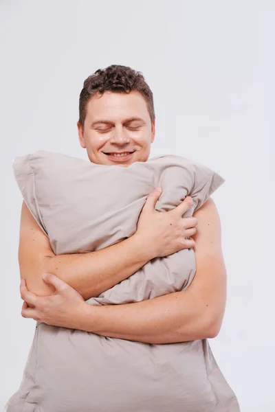 Estúdio retrato de homem sonolento segurando travesseiros — Fotografia de Stock