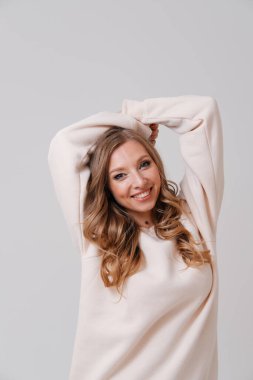 Kollarını açmış genç sarışının stüdyo portresi 