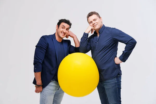 Dos hombres posando con gran bola amarilla — Foto de Stock