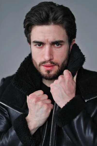 Ein großes Porträt eines stylischen jungen Mannes mit Bart und dunklen Haaren in schwarzer Lederjacke — Stockfoto