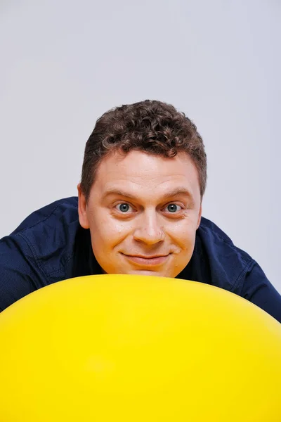 Estúdio retrato de homem posando com grande bola amarela — Fotografia de Stock