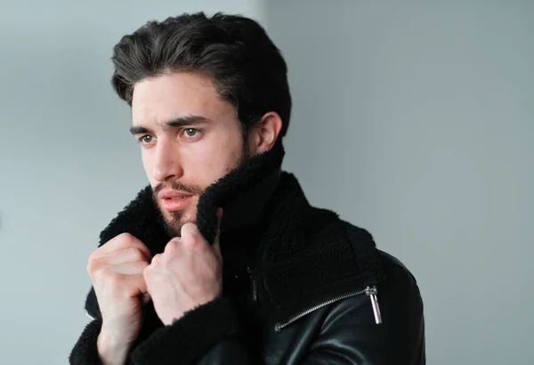 Um grande retrato de um jovem elegante com barba e cabelo escuro em uma jaqueta de couro preto — Fotografia de Stock