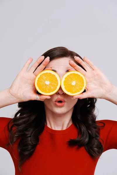 Retrato de morena com laranjas cobrindo olhos — Fotografia de Stock
