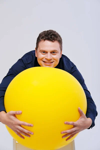 Estúdio retrato de homem posando com grande bola amarela — Fotografia de Stock