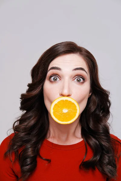 Retrato de morena com laranja cobrindo boca — Fotografia de Stock