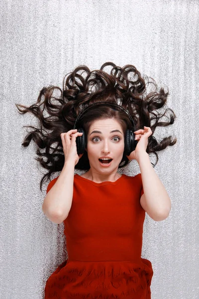 Ξαπλωμένη γυναίκα με ακουστικά και διάσπαρτα μαλλιά — Φωτογραφία Αρχείου