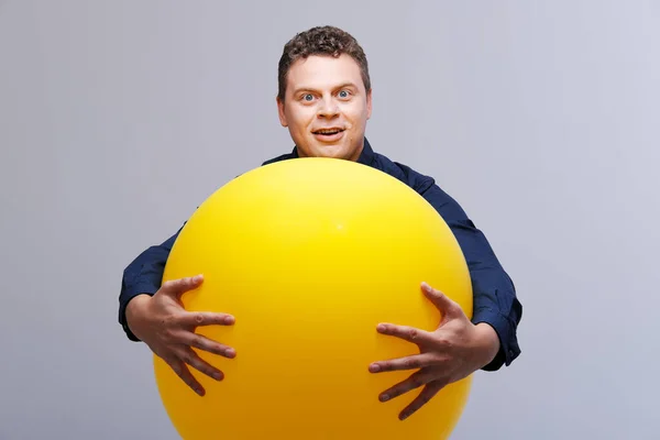 Portrait studio de l'homme posant avec une grosse boule jaune — Photo