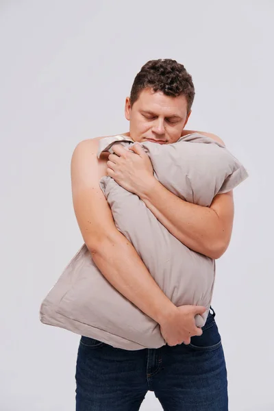 Estúdio retrato de homem sonolento segurando travesseiros — Fotografia de Stock