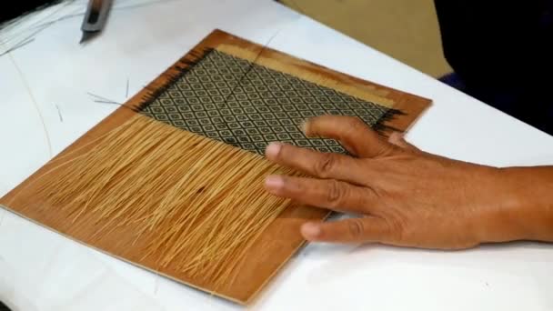 Ремесленник плетет бамбуковые полоски, чтобы сделать плетеный Хит или рисунок Хида — стоковое видео