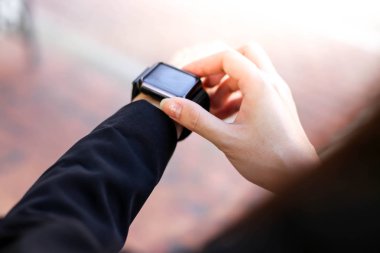  Güzel genç iş kadını akıllı saatine bakıyor.