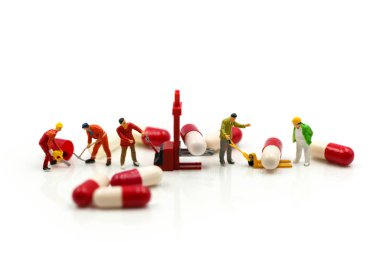 Minyatür insanlar: kapsül ilacı üzerinde çalışan adam sağlıklı olarak kullanıyor.